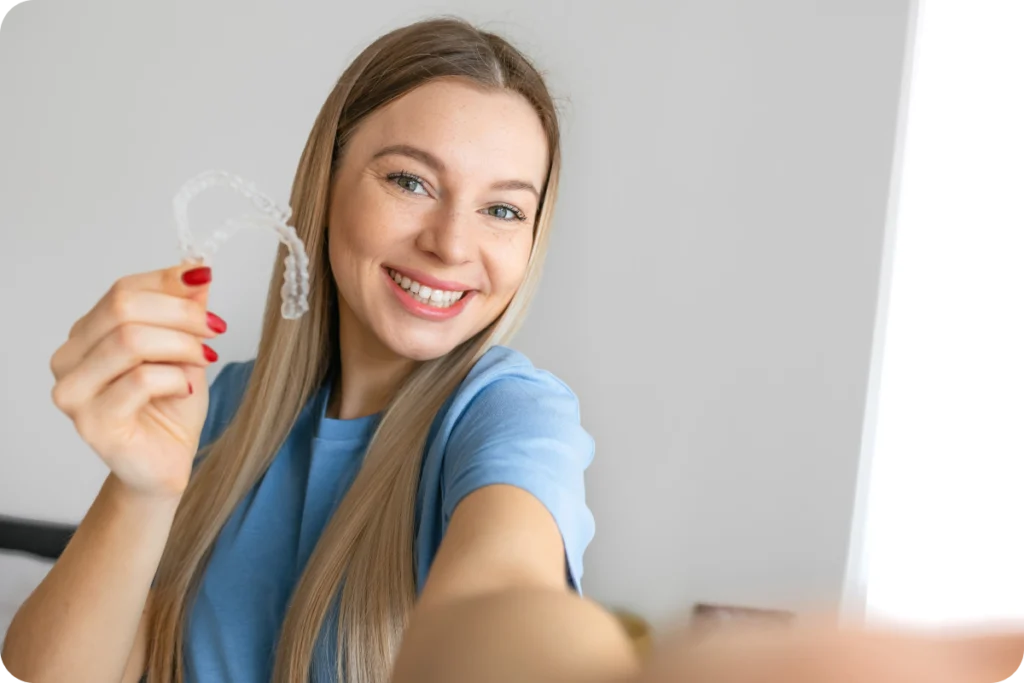 Jeune femme tenant sa gouttière orthodontique transparente
