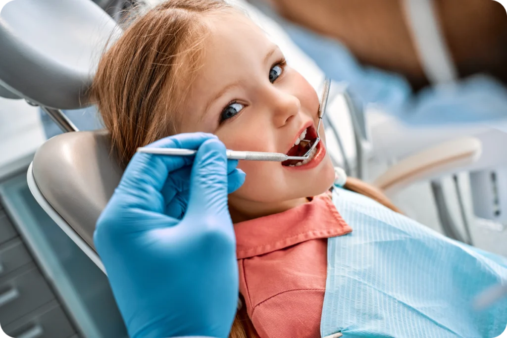 Petite fille examinée au fauteuil par l’orthodontiste